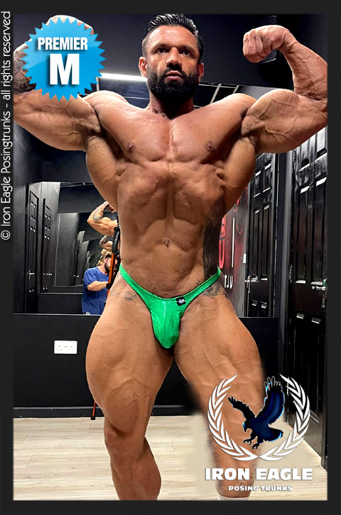 Bodybuilder posing in emerald green holographic posing trunks with a shimmering finish. - Emerald Hologram Mystique - Premier / S / With